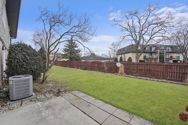 view of yard featuring a residential view, central AC, a patio, and a fenced backyard