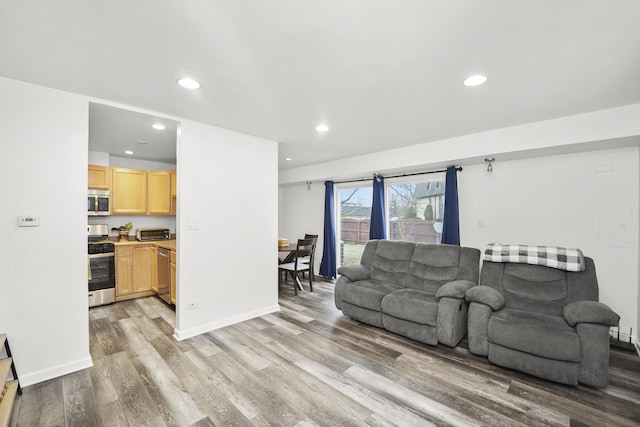 living room with baseboards, a toaster, light wood finished floors, and recessed lighting