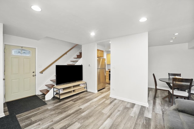 living room with baseboards, stairway, light wood-type flooring, and recessed lighting