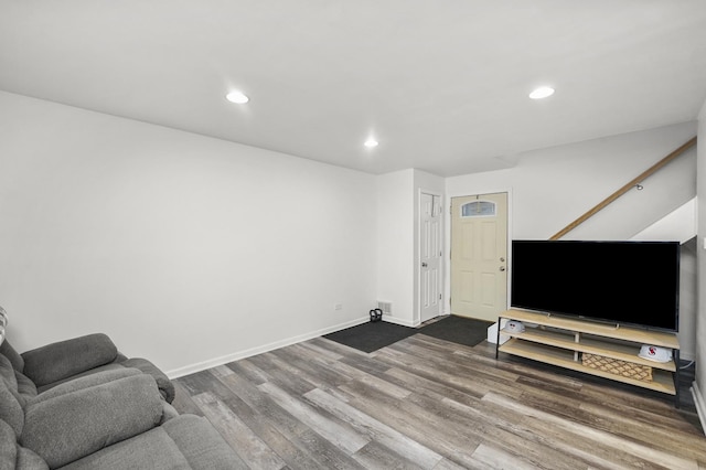 living room featuring baseboards, wood finished floors, and recessed lighting