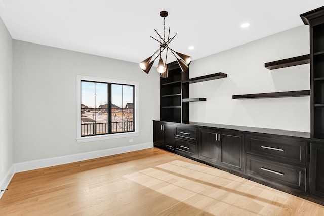 unfurnished living room featuring a chandelier, light wood-type flooring, baseboards, and recessed lighting