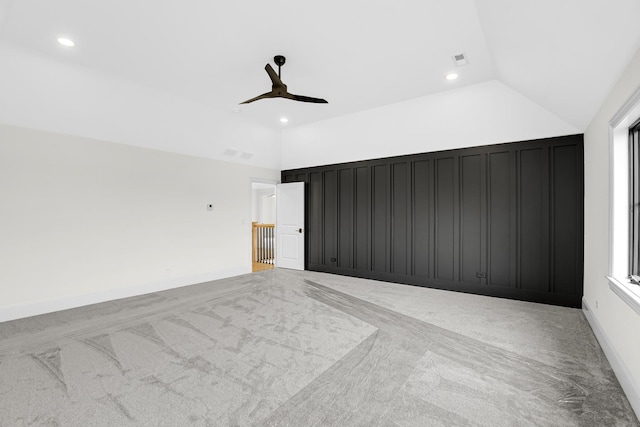 empty room with lofted ceiling, recessed lighting, light colored carpet, visible vents, and baseboards