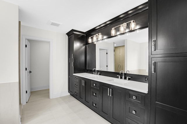 full bathroom with visible vents, a sink, baseboards, and double vanity