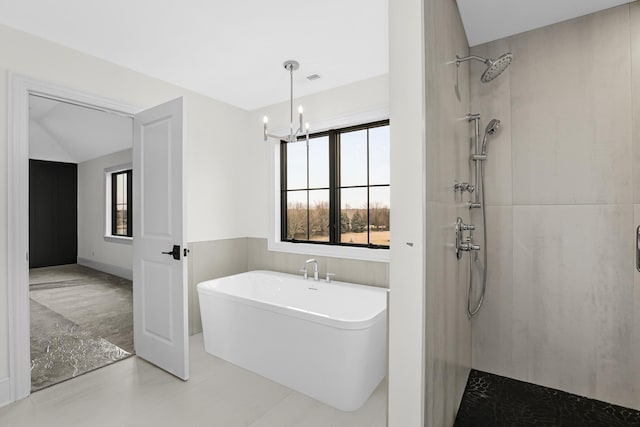 full bath featuring lofted ceiling, a notable chandelier, visible vents, a soaking tub, and a tile shower