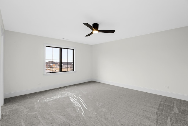 unfurnished room featuring a ceiling fan, carpet, and baseboards