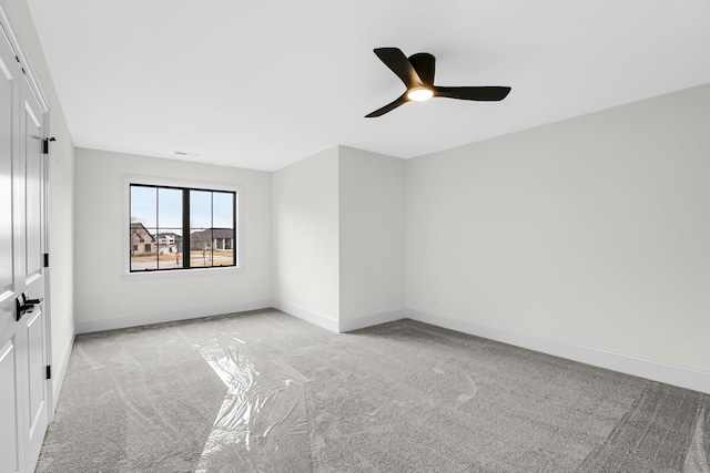 unfurnished room featuring light carpet, ceiling fan, and baseboards