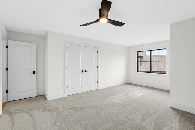 unfurnished bedroom with carpet floors, a closet, and baseboards