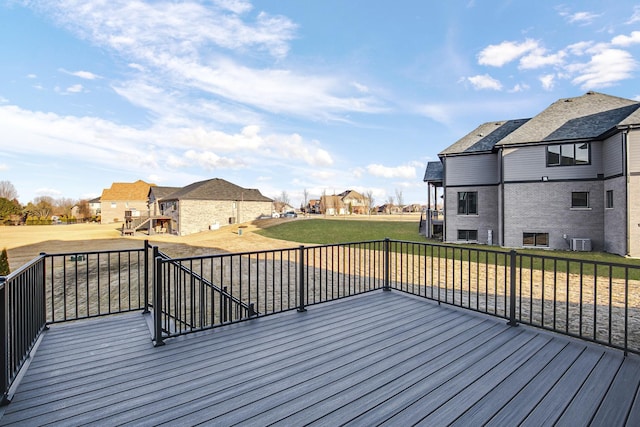 deck with a residential view, a yard, and central air condition unit