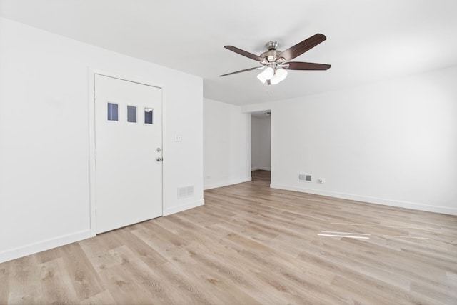 spare room featuring baseboards, light wood-type flooring, visible vents, and a ceiling fan