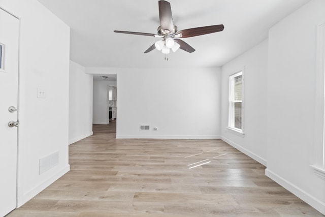 spare room with visible vents, light wood-style flooring, and baseboards