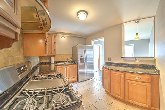 kitchen featuring stainless steel appliances, brown cabinets, decorative backsplash, and light tile patterned floors