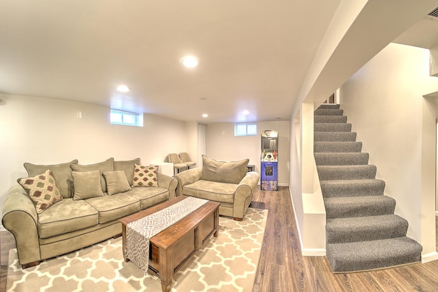 living area featuring a healthy amount of sunlight, stairway, wood finished floors, and recessed lighting