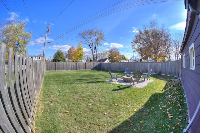 view of yard with a fenced backyard, a fire pit, and a patio