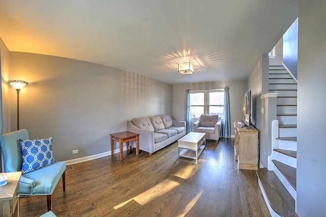 living room featuring stairs, dark wood-style floors, and baseboards