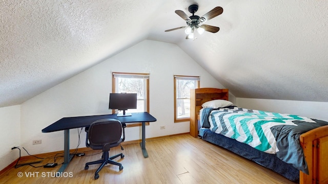 bedroom featuring lofted ceiling, a ceiling fan, a textured ceiling, wood finished floors, and baseboards