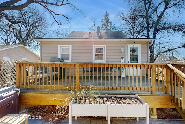 back of property featuring a chimney and a wooden deck