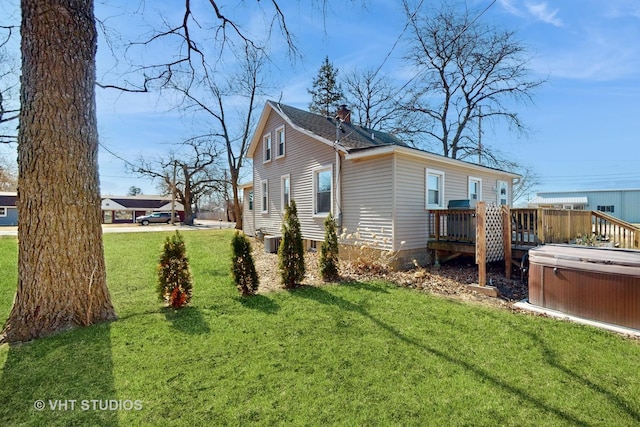 view of home's exterior featuring a chimney, a lawn, a hot tub, central AC, and a deck