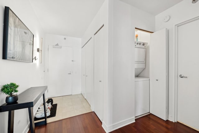 hall with wood finished floors and stacked washer / drying machine