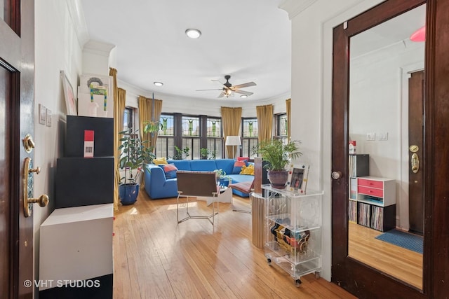 interior space with ceiling fan, crown molding, and hardwood / wood-style flooring