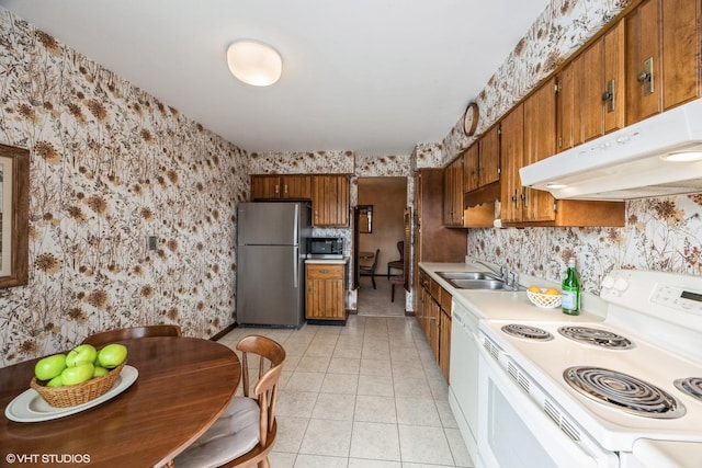 kitchen with stainless steel appliances, brown cabinetry, and wallpapered walls