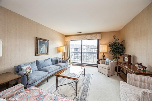 carpeted living room with wallpapered walls and visible vents