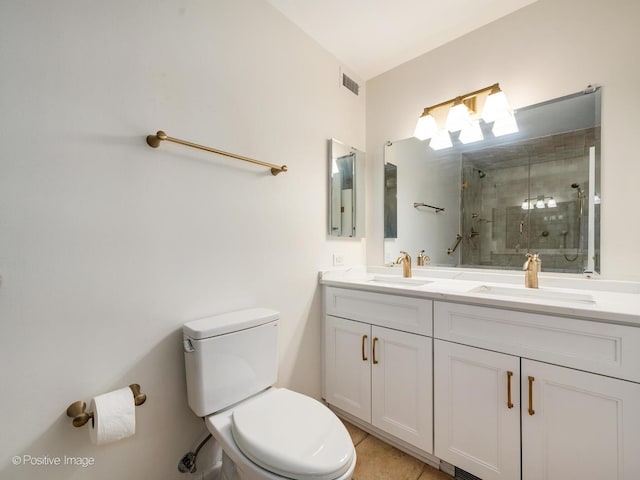 bathroom featuring a stall shower, visible vents, a sink, and toilet