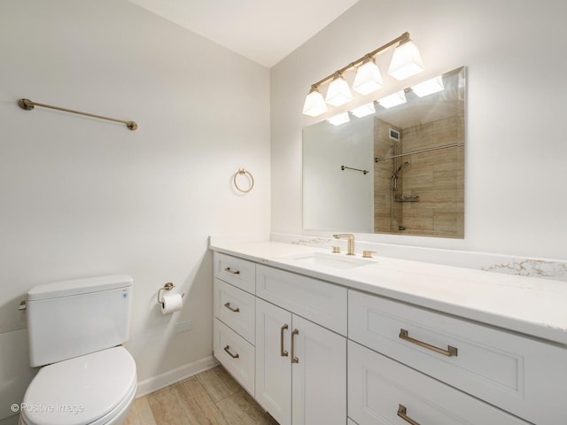 full bath featuring toilet, tiled shower, and vanity