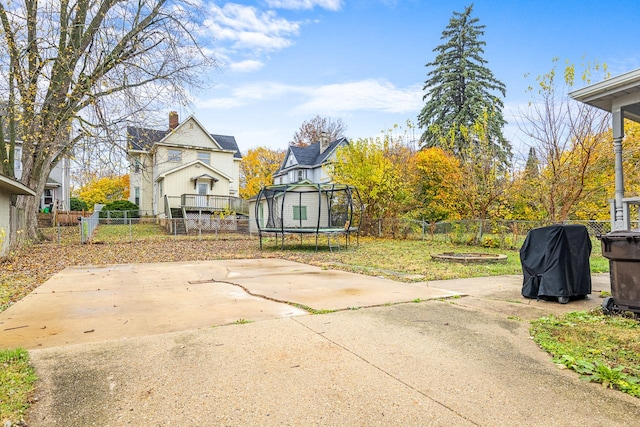 view of yard featuring a fenced backyard, a trampoline, and a patio