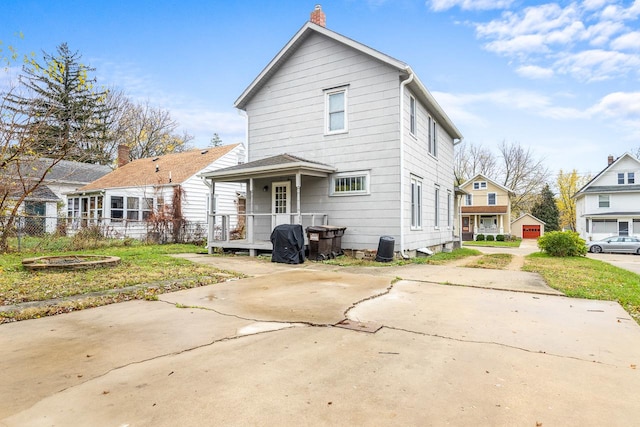 back of house with covered porch and a yard