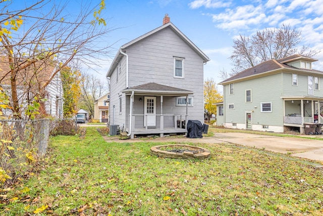 rear view of house featuring a yard, central AC, a chimney, and fence