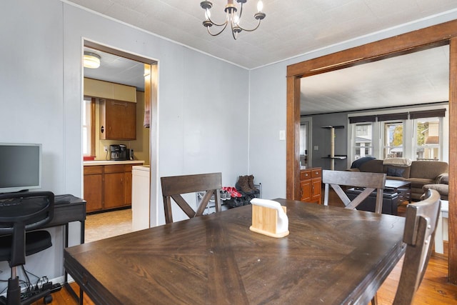 dining space featuring light wood finished floors and a notable chandelier