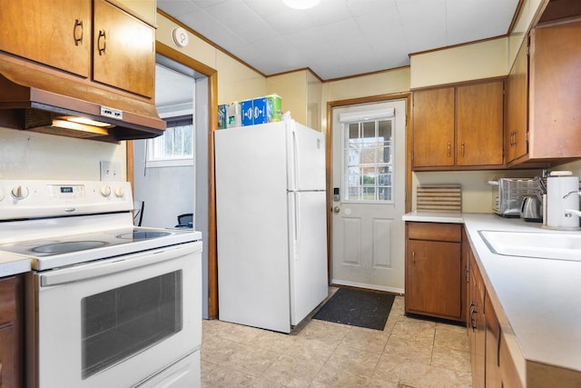 kitchen with white appliances, light countertops, ornamental molding, brown cabinets, and custom range hood