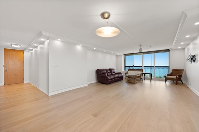 sitting room featuring expansive windows, baseboards, light wood-style flooring, and recessed lighting