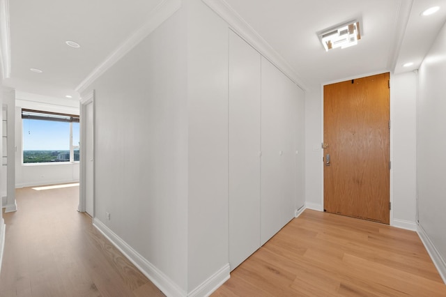 hallway featuring baseboards, ornamental molding, recessed lighting, and light wood-style floors