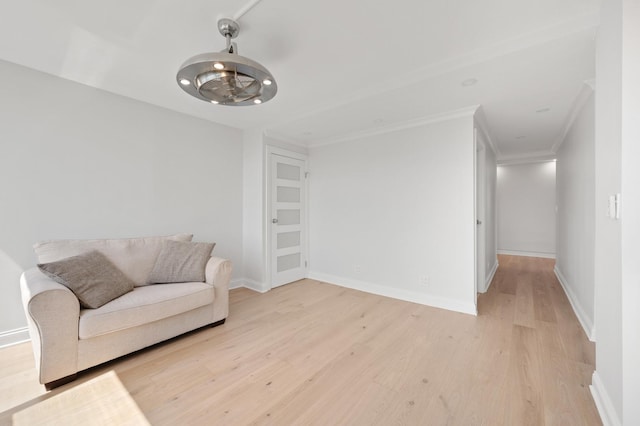 living area featuring ornamental molding, light wood-type flooring, and baseboards