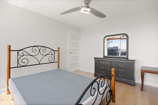 bedroom with light wood-type flooring, ceiling fan, and baseboards