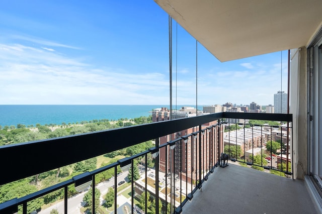 balcony with a water view and a view of city