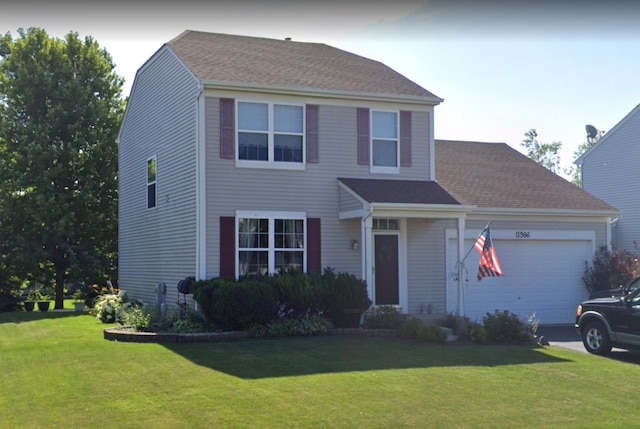 view of front of property featuring a front yard, roof with shingles, driveway, and an attached garage