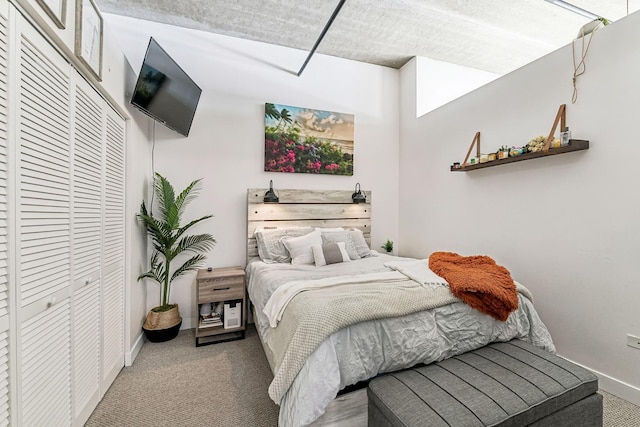 carpeted bedroom with a closet and baseboards