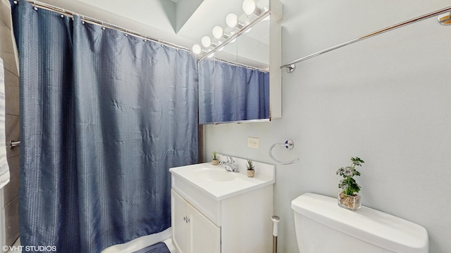 bathroom featuring curtained shower, vanity, and toilet