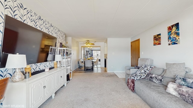 living area with light carpet and ceiling fan