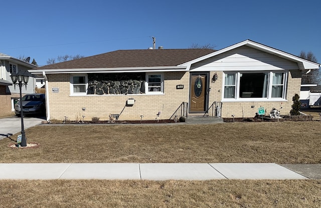 single story home with a front lawn, roof with shingles, and brick siding