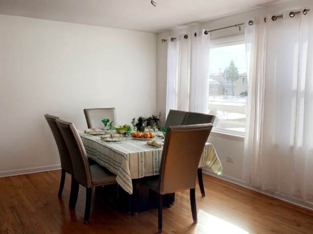 dining space featuring wood finished floors and baseboards