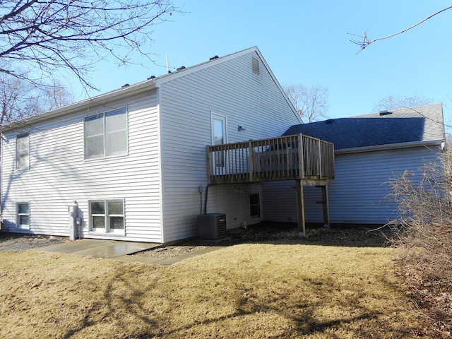 back of property with central AC, a yard, and a wooden deck