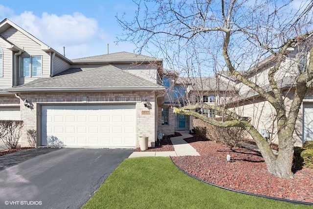 view of front of property featuring driveway, brick siding, an attached garage, and roof with shingles