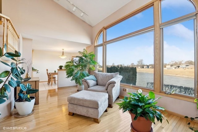 sunroom with vaulted ceiling and track lighting