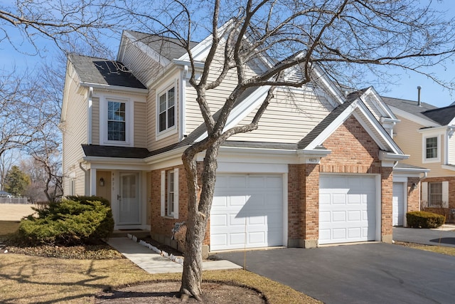 view of front of house with aphalt driveway, a garage, and brick siding