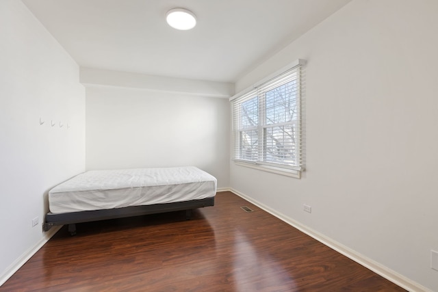 bedroom with visible vents, dark wood-type flooring, and baseboards