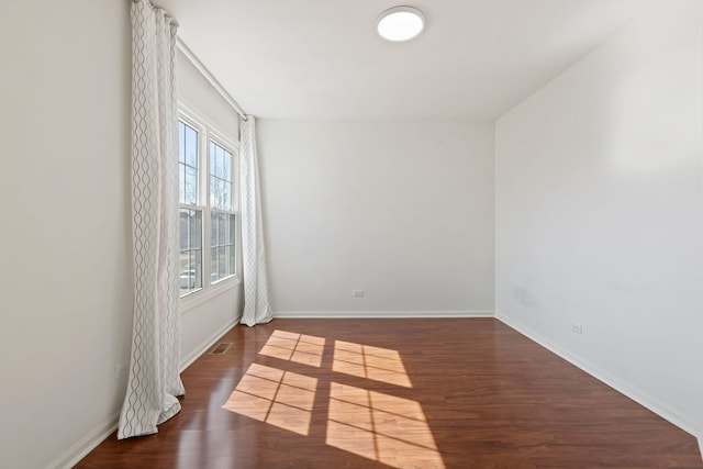 unfurnished room featuring baseboards and wood finished floors