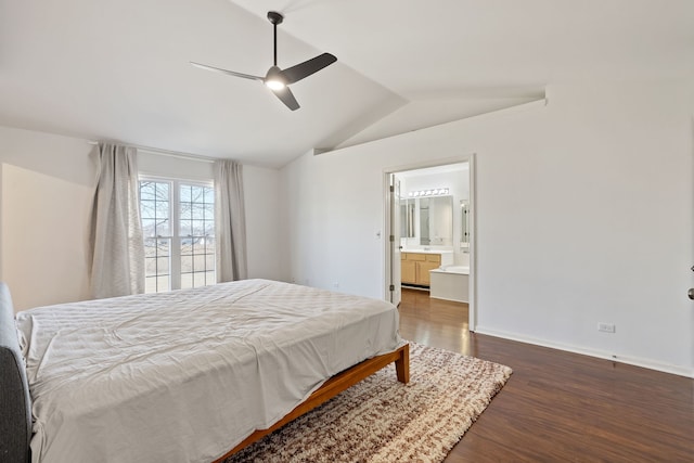 bedroom featuring wood finished floors, baseboards, ensuite bath, lofted ceiling, and ceiling fan